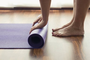 Yoga sınıfındaki mor minderli kadın. 