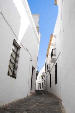 Vejer, Endülüs 'teki beyaz evlerin arasından yokuş yukarı giden boş bir cadde. Turistik eğlence, yaz tatili, rehberli tur, seyahat yeri kavramları.