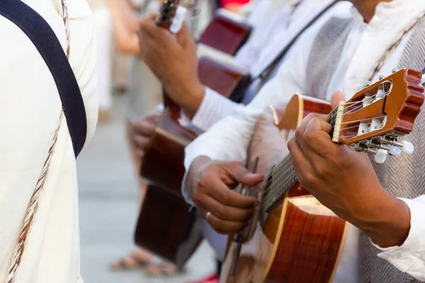 Las Palmas, İspanya 'da yerel kostümler giyen gitaristlere yakın çekim. Geleneksel kıyafetlerle müzik grubu özel etkinlikte enstrüman çalıyor. Kanarya Adaları 'nda parti kutlaması yapan müzisyenler