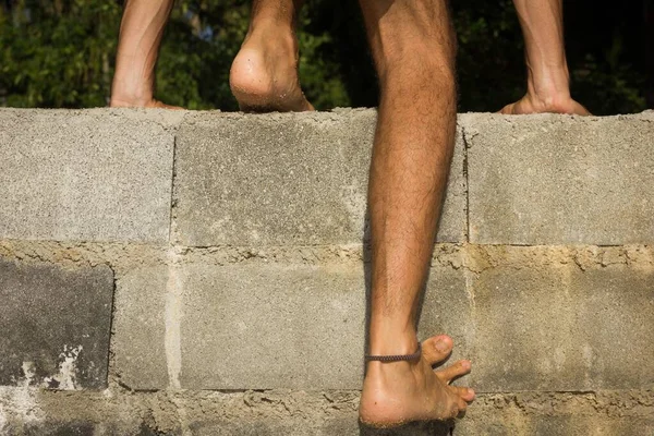 Close Legs Barefoot Man Climbing Brick Wall Immigration Trespassing Concept — Stock Photo, Image