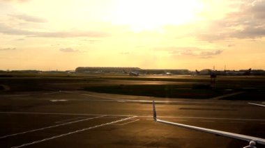 İngiltere, Londra 'daki Heathrow havaalanından gün batımında kalkan uçak.