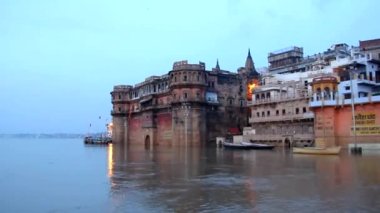 Ganj Nehri 'nin kıyısında gün doğumunda tekne gezintisi. Hindistan, Varanasi' deki binaların ve ghatların bir kısmını su basmış.