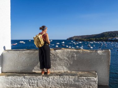 Young girl enjoying the scenery of Cadaques on a sunny day.