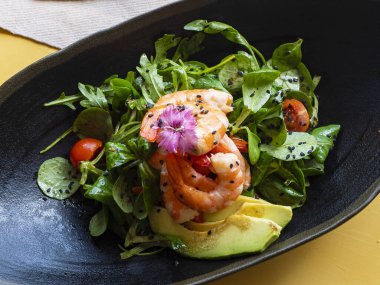 Lezzetli deniz ürünleri haşlanmış somon salatası, karides, roka, domates ve fesleğen.