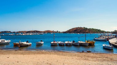 Kadavra 'da gün batımında deniz ve tekneler olan güzel bir sahil.