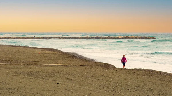 Vrouw Rode Jurk Wandelen Het Strand Met Een Golf Achtergrond — Stockfoto