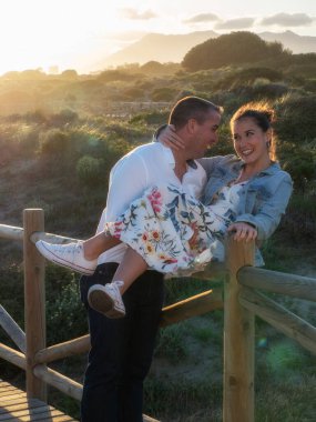 Birbirini seven bir çift, deniz kenarında parkta geziniyor.