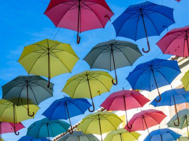 Mavi gökyüzünde renkli şemsiyeler