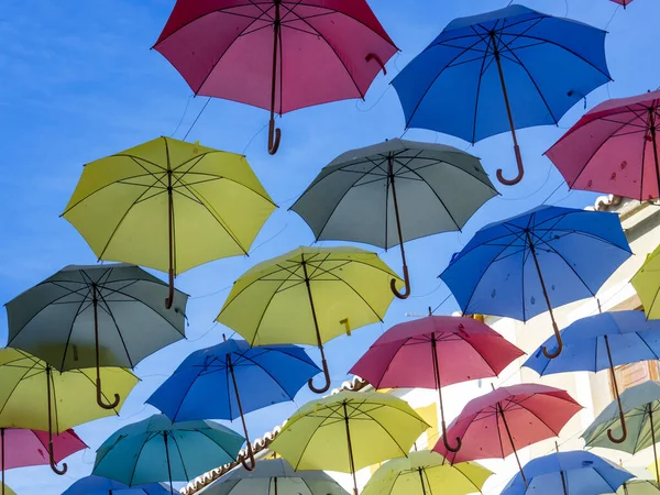 Mavi gökyüzünde renkli şemsiyeler