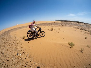 Merzouga, Fas. Eylül 2021. Genç çocuklar Fas 'ın Sahra Çölü' nde bisiklet ve motosiklet sürüyorlar..