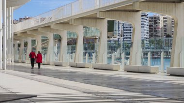 Bir çift, Malaga, İspanya limanlarından birinde rıhtımda geziniyor.