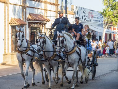 Fuengirola, Malaga, İspanya. 10/12/2023. Ekim fuarı boyunca Fuengirola sokaklarında at sırtında tipik Endülüs kostümü giymiş kadınlar.