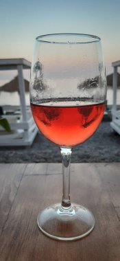 Sahilde bir bardak kırmızı şarap