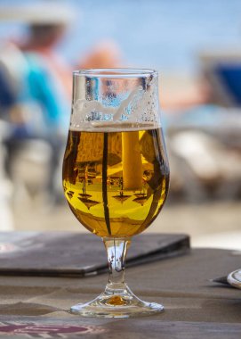 Masada bir bardak bira ve bir şişe bira.