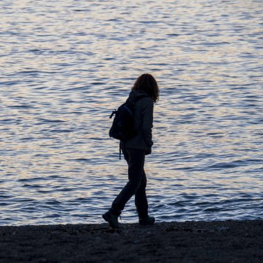 Gün batımında sahilde yürüyen bir kişinin silüeti, Cabo de Gata, Almeria, İspanya