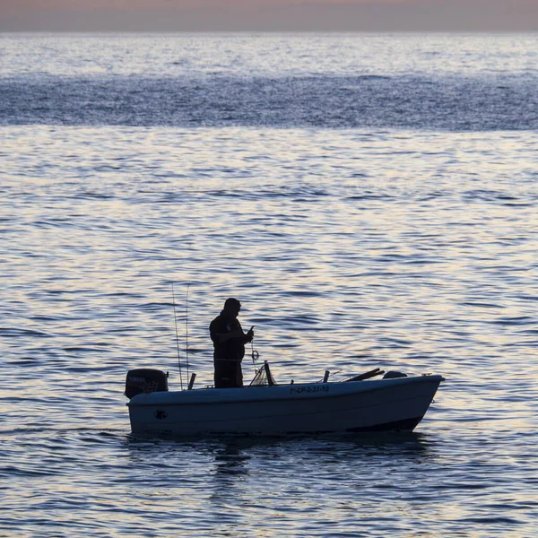 a fisherman is fishing on the ocean