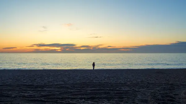 silhouette of a person walking on a beach at sunset, Cabo de Gata, Almeria, Spain
