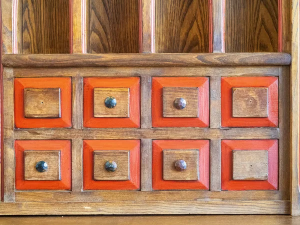 a wooden cabinet with many drawers and knobs