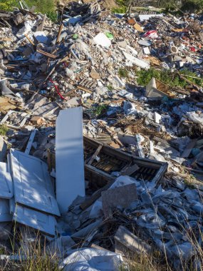 Ortasında beyaz bir buzdolabı olan enkaz ve moloz yığını.