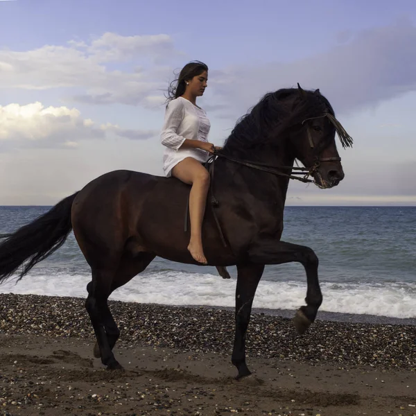 Sahilde ata binen bir kadın.