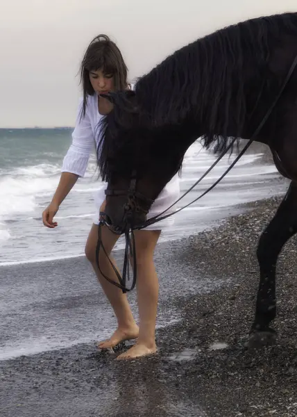 Sahilde at gezdiren bir kadın.