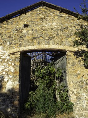 Tahta kapılı ve saatli taş bir bina.