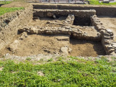 Elinde atla binanın önünde duran bir adam.