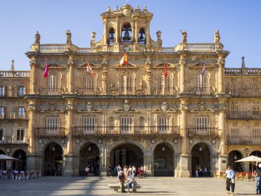 Saat kulesi olan büyük bir bina ve bir sürü insan.