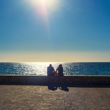 Salobrea, Granada, İspanya. 06/16/2021. İspanya 'nın Granada kentindeki Salobrena plajlarının keyfini çıkaran turist siluetleri.