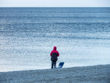 Sahilde elinde uçurtmayla duran bir insan.