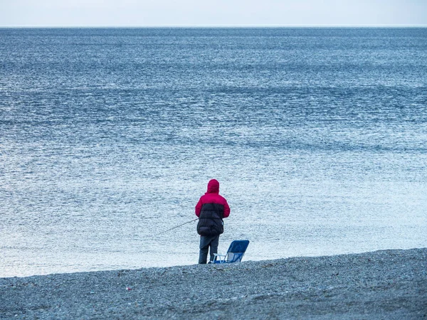 Sahilde elinde uçurtmayla duran bir insan.