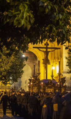 Bir grup insan haçın etrafında dikiliyor.