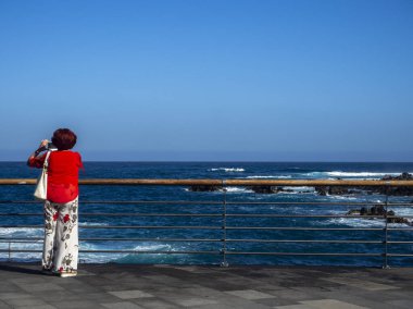 Kumsalda sırt çantalı bir kadın.