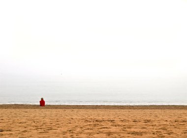 Torremolinos plajında kırmızı ceketli güzel bir kadın.