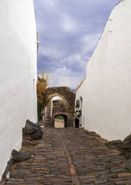 Portekiz 'in Alentejo bölgesindeki ortaçağ Monsarrat köyünün taş kemerli giriş kapıları..