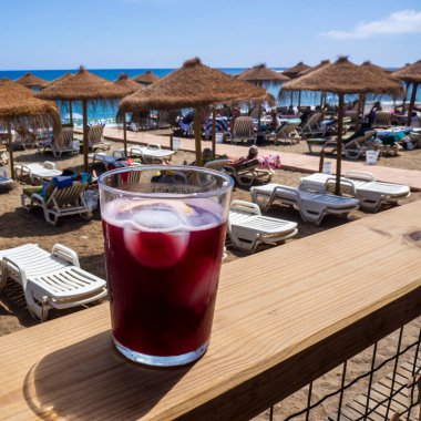 Malaga sahilinin arka planında buzlu kırmızı şarap.