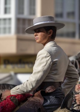 Fuengirola, İspanya. 09/23/2024. Tipik Endülüs kostümü giymiş genç bir adam Fuengirola 'da at günü safkan bir İspanyol atına biniyor..