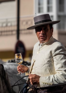 Fuengirola, İspanya. 09/23/2024. Tipik Endülüs kostümü giymiş bir binici Fuengirola 'daki At Günü kutlamalarında safkan bir İspanyol atına biniyor..