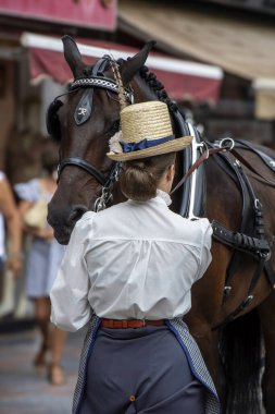 Fuengirola, İspanya. 09/23/2024. İnsanlar tipik Endülüs kostümleri giyip Fuengirola 'daki At Günü kutlamalarında klasik bir arabaya biniyorlardı..