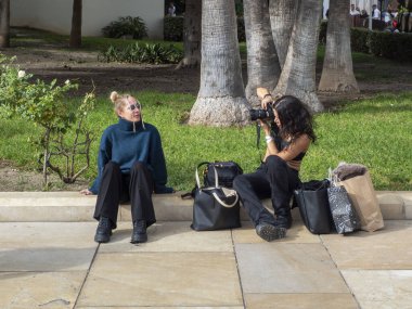 12/07/2024. Malaga, İspanya. Malaga 'nın merkezindeki bir sokakta fotoğraf çekimi yapan iki arkadaş..