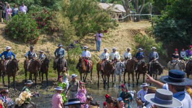 Almonte, Huelva, İspanya. Hacılar geleneksel hac yolculuğunda El Rocio köyü yakınlarındaki Quema nehrinden yaya olarak geçerek bakirelerin inzivasına giderler..