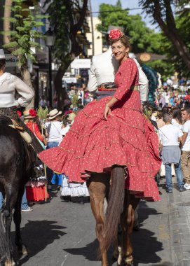 Fuengirola, Mlaga, İspanya. 28 Eylül 2025. Fuengirola 'daki Bakire Meryem' in kutsal yolculuğu için süslü arabaların önünde geleneksel Endülüs elbisesi giyen çift..