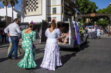 Fuengirola, Mlaga, İspanya. 28 Eylül 2025. Fuengirola Bakiresi 'nin kutsal yolculuğu için süslü arabaların arkasında geleneksel Endülüs kostümleri giyen geniş insan grupları..