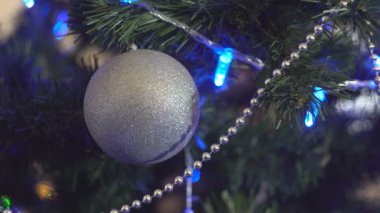 Noel ağacı ve çelenklerin parıldayan ışıkları için Noel süslemeleri. Parlak mücevherlerle süslenmiş Noel süsleri yeni yıl tatili için çam dalları süslüyor.