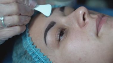 Kız kırışıklıkları azaltmak için besleyici bir kömür maskesi takıyor. Mavi baloncuk maskeli bir kadının yüzünü yakından çek. Karbonatlı baloncuk maskesi.