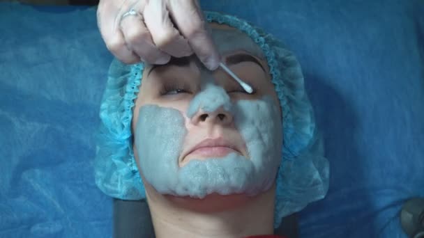 少女はしわを減らすために栄養炭マスクを適用します 青い泡の粘土マスクで女性の顔のクローズアップ 石炭化バブル粘土マスク — ストック動画