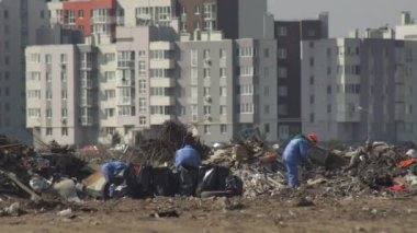 Çöp ayıklama konsepti. Erkekler ve kadınlar geri dönüşüm için özel çöp torbalarına çeşitli atıklar koyarlar. Taşınabilir karakterler çevreyle ilgilenir ve çöpleri atar..