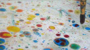 Suyun üzerine çok renkli suluboya damlaları. Küçük çocuklar için hafta sonu eğlencesi. Çocukların yaratıcılığının gelişimi.