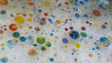 Suyun üzerine çok renkli suluboya damlaları. Küçük çocuklar için hafta sonu eğlencesi. Çocukların yaratıcılığının gelişimi.
