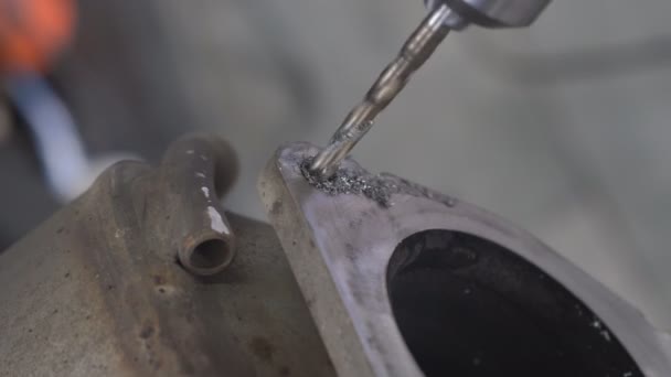 在汽车加油站钻探金属的过程 钻具在排气系统的一个很大的金属部分打了一个深孔 在车间里用机械工具钻金属制品 — 图库视频影像